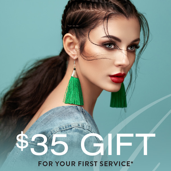 Woman with braided hair and green tassel earrings looks over her shoulder against a teal background. Text reads "$35 gift for your first service*" on select haircuts, including balayage and highlights.