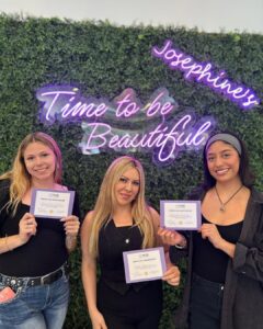 SnapInsta.to_502773691_18505563277051250_1969067463018464624_n Three women at a luxury Aveda salon and spa in Houston, TX, smile before a lush green wall and neon "Time to be Beautiful" sign, celebrating their beauty certification. | Josephine's Salons and Spas | Houston, TX