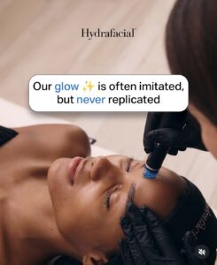 A client at a luxury Aveda salon and spa in Houston, TX enjoys a HydraFacial from a gloved esthetician. Text: “Our glow is often imitated, but never replicated.”. | Josephine's Salons and Spas | Houston, TX