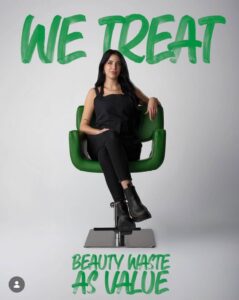 A woman sits in a green salon chair at a sustainable luxury Aveda salon in Houston, TX, beneath text stating “We treat beauty waste as value” as part of a commitment to eco-friendly beauty. | Josephine's Salons and Spas | Houston, TX